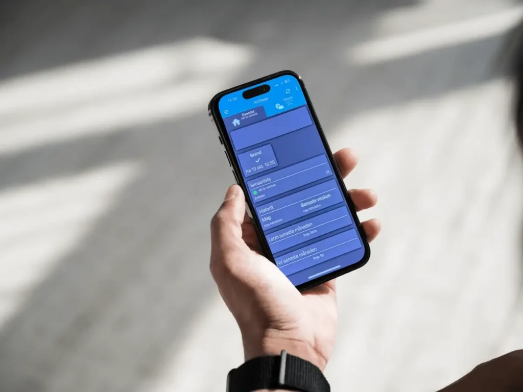 hand som håller i en mobiltelefon som visar X2 app